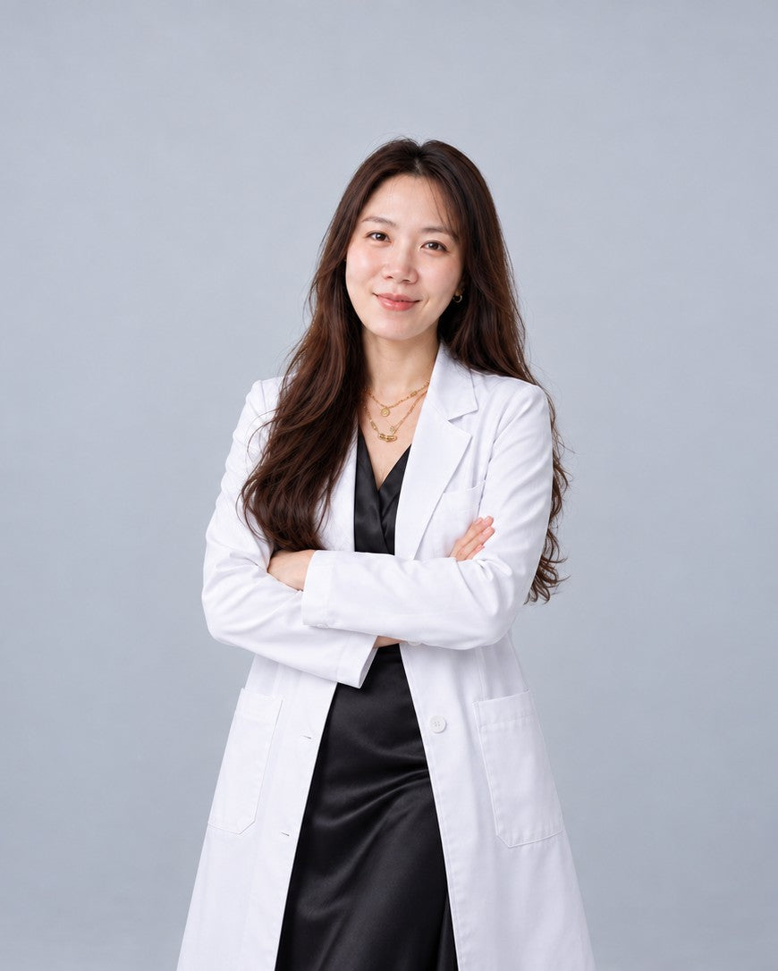 Clara Song, PhD, founder and formulator of COMPLETE ELIXIR, in a white laboratory coat with arms crossed